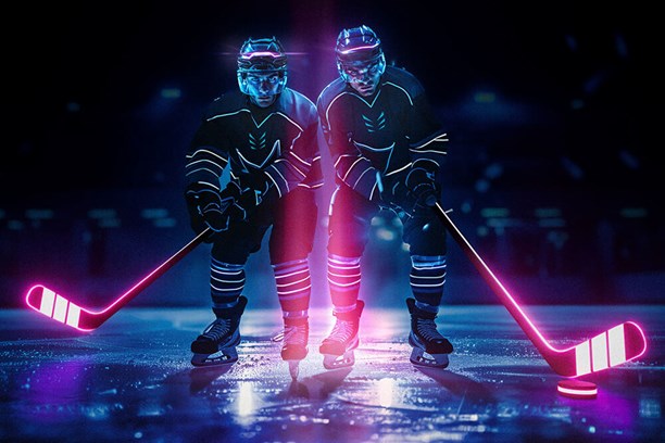 Protect & Connect Zwei Eishockeyspieler auf dem Eis mit rosa leuchtenden Schlägern in der Hand