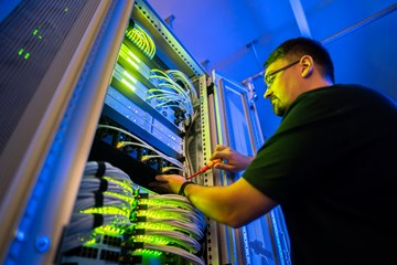 Datacenter Ein Mitarbeiter der envia TEL arbeitet an einem Serverschrank