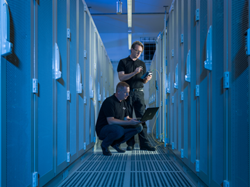 Checkliste-Rechenzentrum IT Techniker im Datacenter vor Serverschränken