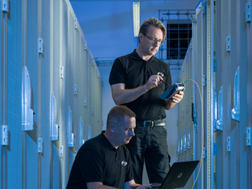 Checkliste-Rechenzentrum IT Techniker im Datacenter vor Serverschränken