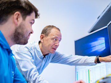 Praktikum bei envia TEL Auszubildender und Ausbilder vor Computern