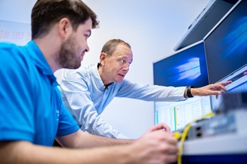 Praktikum bei envia TEL Auszubildender und Ausbilder vor Computern